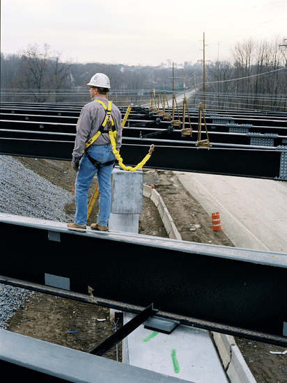 Construction workers connected to a portable fall arrest system