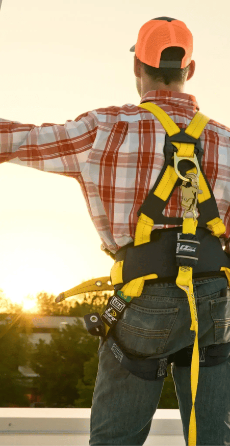 Worker on rooftop with fall protection PPE