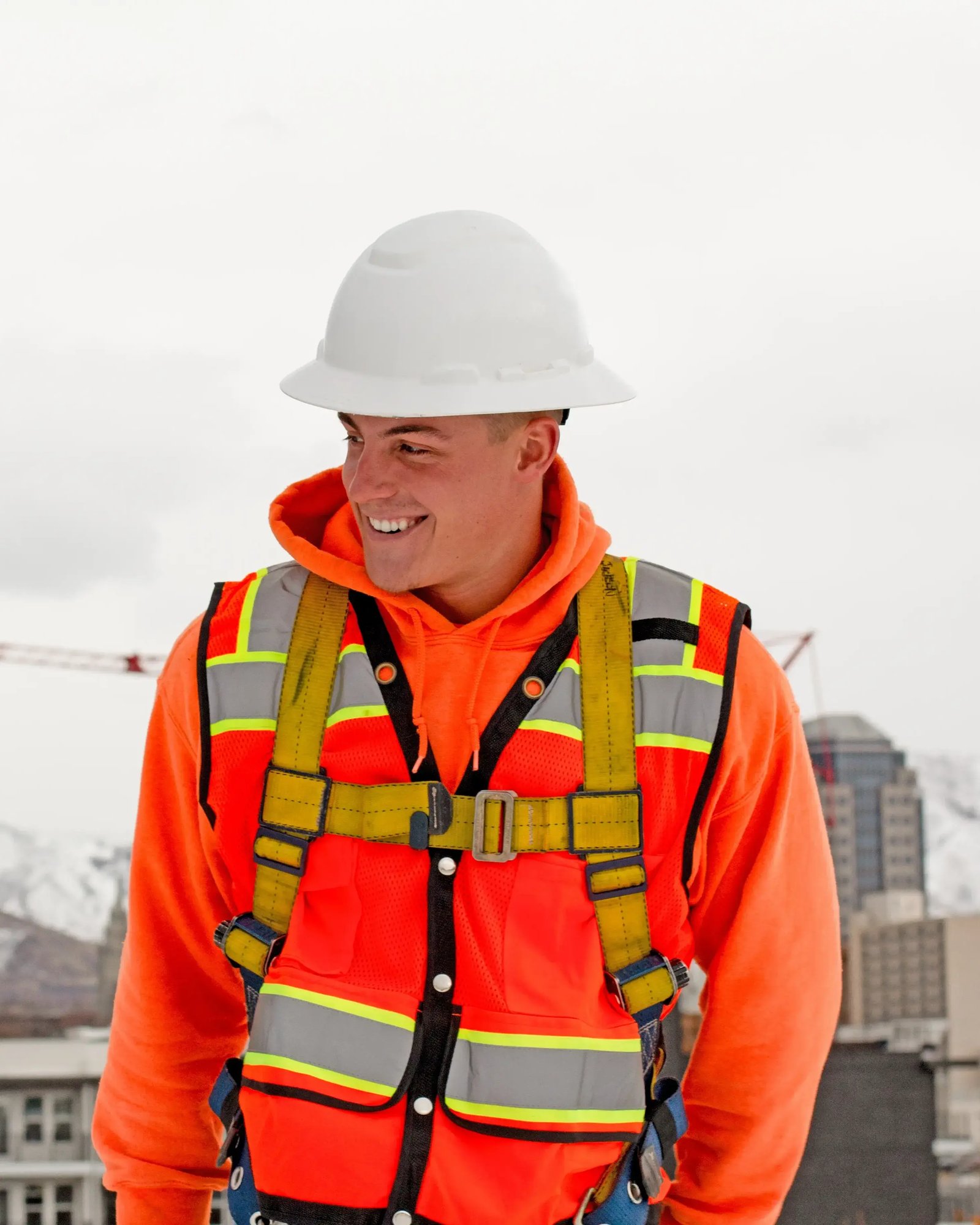 smiling worker on rooftop wearing PPE