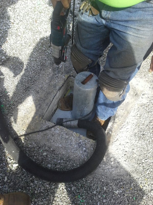 installation workers inserting rigid post. Both of the workers feet (size 12 boot) can fit into the hole along with the post.