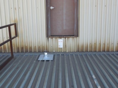 a horizontal lifeline with tipover anchor on a corrugated metal roof.