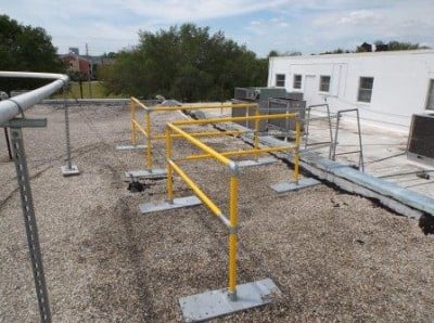 Non-penetrating rooftop ladder access guardrail