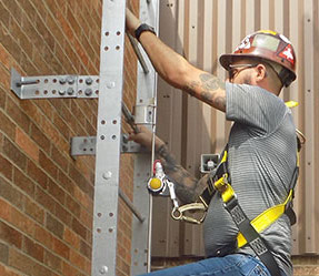 man climbing roof access ladder